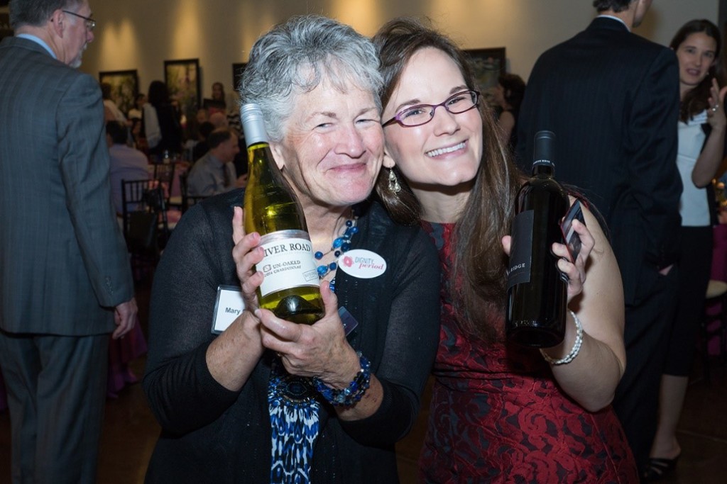 Two of last year’s wine pull participants display their winnings.  